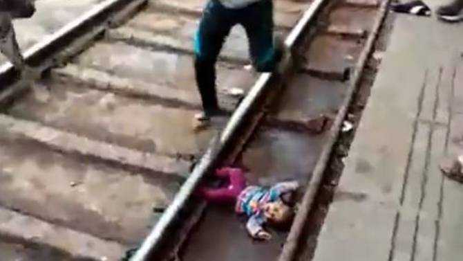 Baby unscathed after falling onto train tracks in India