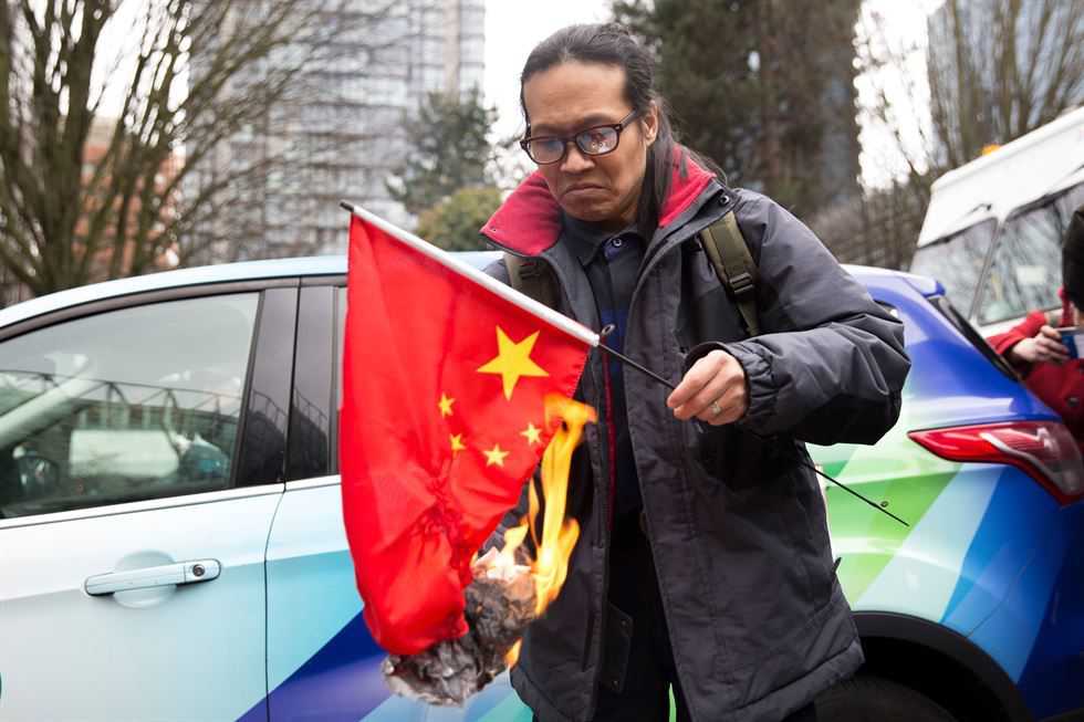 Protester burns Chinese flag outside Huawei CFO's court hearing