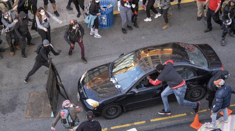 Man drives car into protesting crowd in Seattle, shoots bystander
