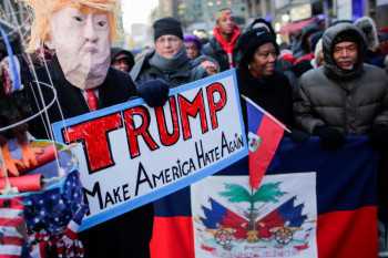 Trump marks King day out of view, buffeted by race claims