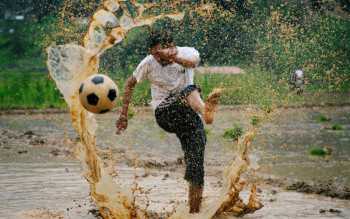 A man kicks a football as he takes part in an event celebrating National Paddy Day